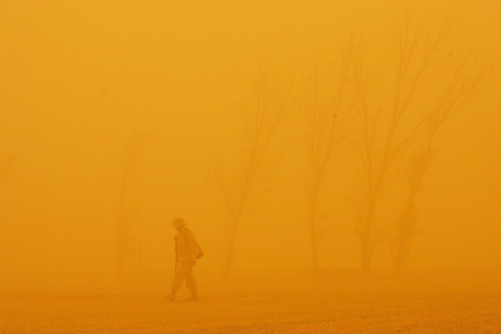 Figures in a dust-filled landscape